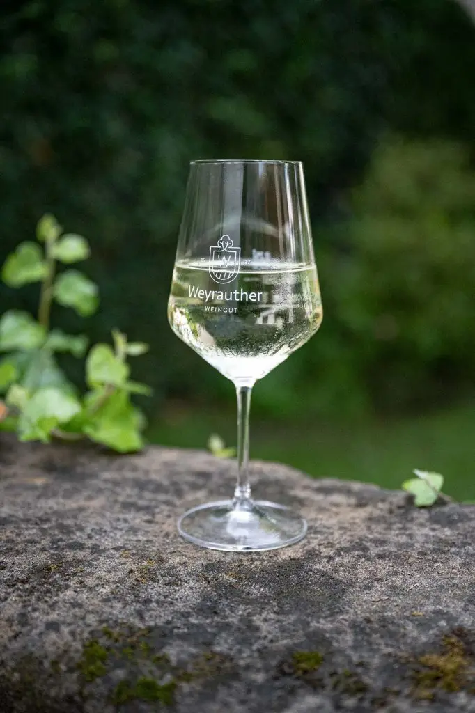 Silvaner im Weinglas mit Log Weingut Weyrauther eingraviert.