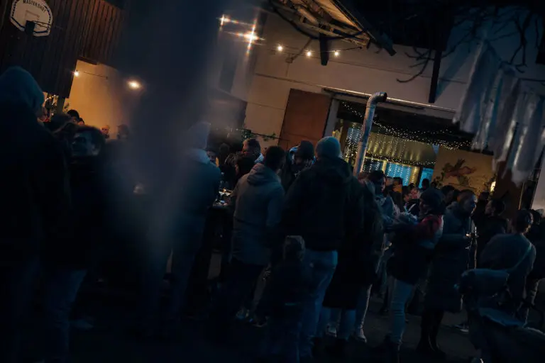 Menschenmenge mit Glühwein und Lichterketten beim Winterfest 2025 am Weingut Weyrauther in Unterhaid